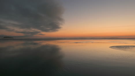 beautiful oregon coast background of sunset at beach with cloud reflecting in wet sand