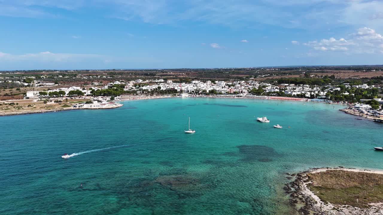 Blue lagoon with boats and township in background, aerial view