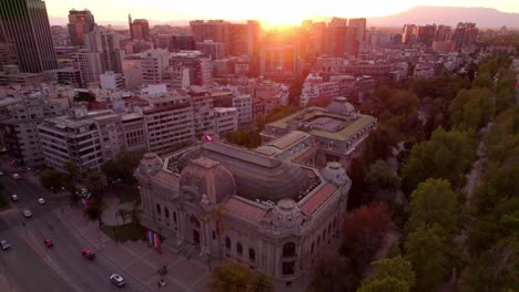 golden hour sun rise above santiago chile city center museum of fine arts aerial drone flying above downtown traffic and urban park, parque forestal