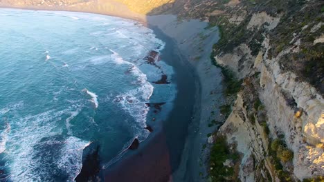 Closing-on-cliff-range-at-beach-during-sunset-in-Matanzas,-Navidad-region-in-the-south-of-Chile