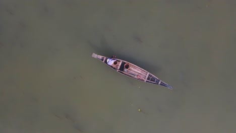 vista aérea de pájaros de un pescador solitario en un barco de madera tradicional flotando en el río ichamati