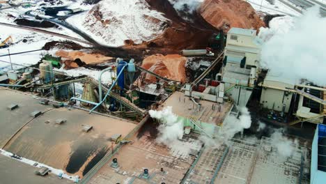 Vista-Aérea-De-Los-Edificios-En-Un-Aserradero-En-Invierno:-Toma-De-La-Manipulación-De-Materiales-De-Desecho-En-Acción