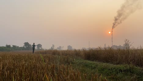 Front-shot-of-young-man-jogging-on-countryside-rural-road-with-Glas-Plant-behind-at-winter-morning