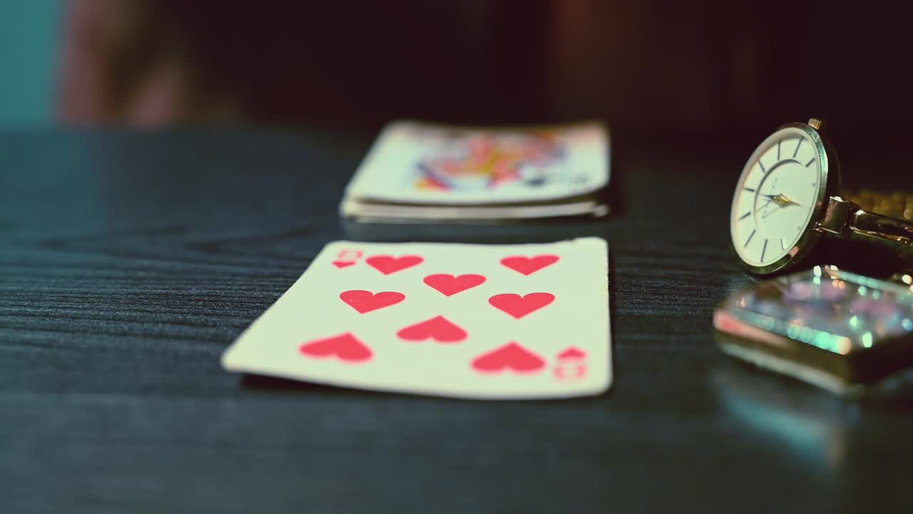 Fortune teller hands puts three cards on a table among mysterious bright jewelry. Cinematic move from right to left side. Close up. Slow motion