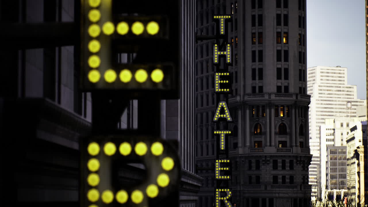 Neon lights illuminate downtown theater district during evening hours