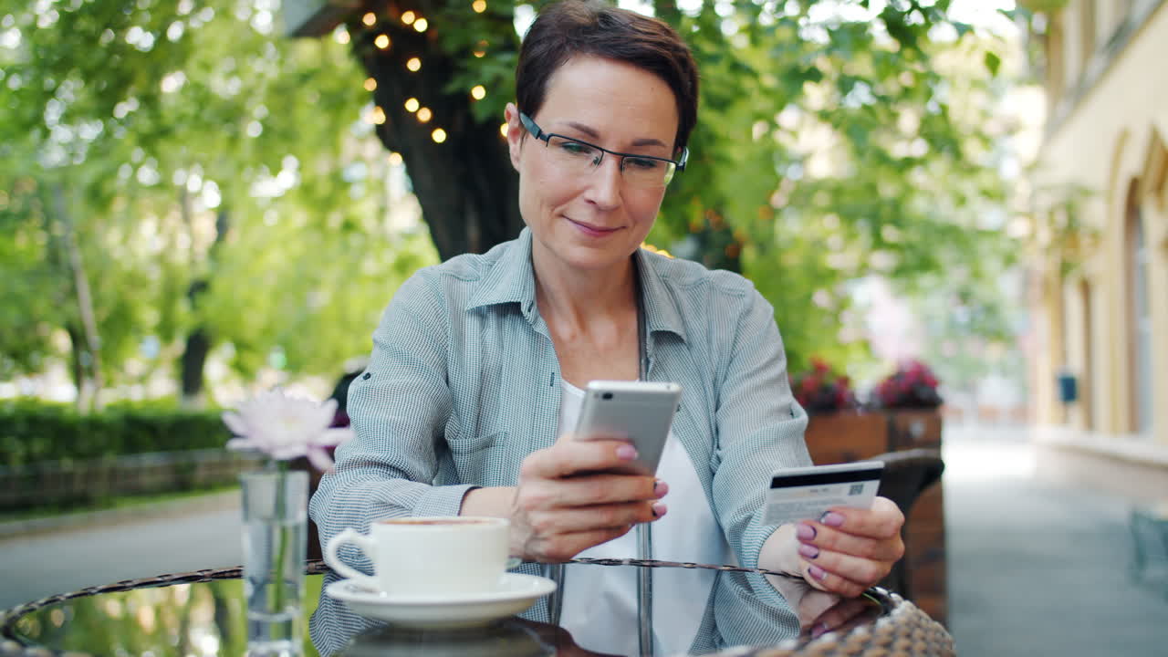 Woman using mobile payment at outdoor cafe