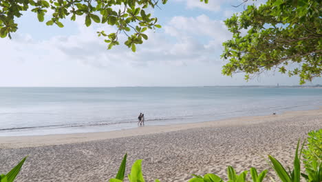 Pareja-Paseando-Por-Una-Playa-Tranquila-Con-Arena-Blanca-En-El-Resort-Intercontinental-Bali,-Bali,-Indonesia