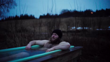 man relaxing on outdoor hot tub at night