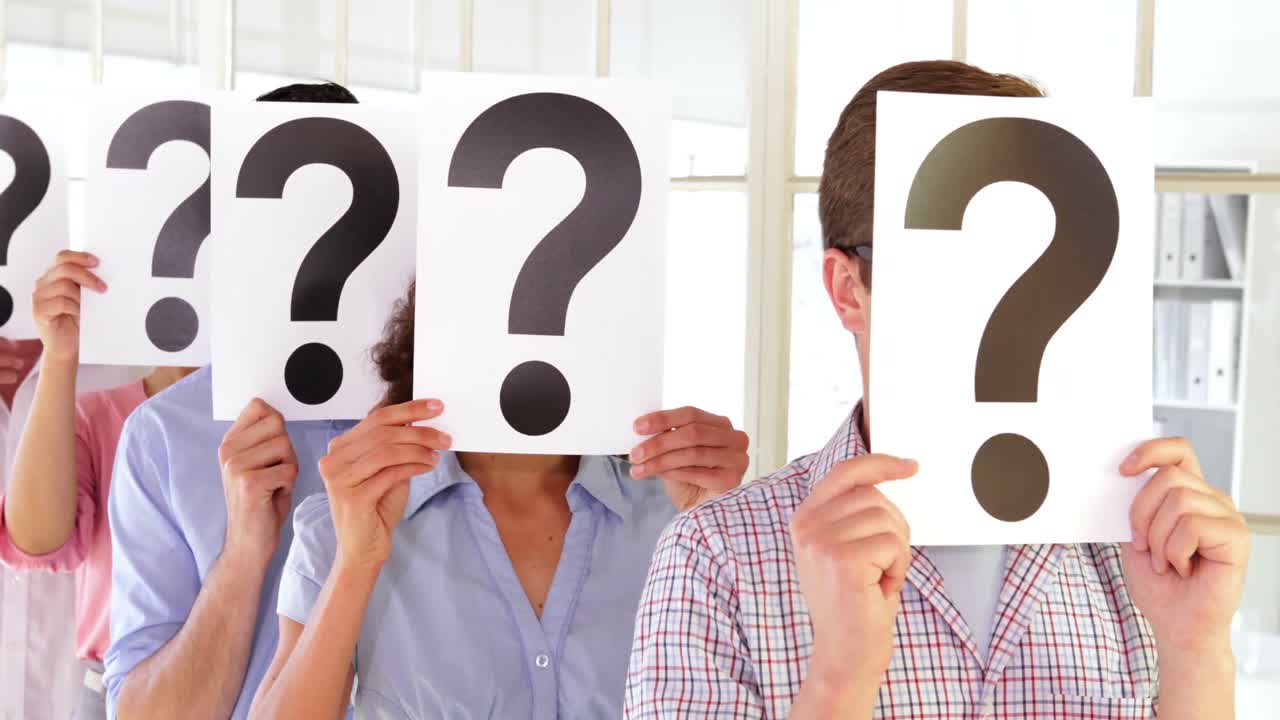 jóvenes de pie en una fila sosteniendo un cartel frente a sus caras