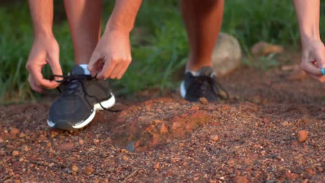 Couple-tying-their-laces-of-running-shoes