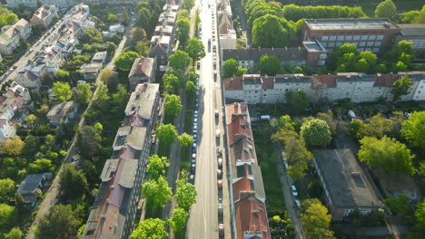 Vista-Aérea-Del-Distrito-Residencial-Y-La-Línea-De-Autos-Estacionados-En-La-Calle-A-Lo-Largo-De-Los-Edificios-En-Gdansk-Al-Atardecer,-Tiro-Revelador-Inclinado-Hacia-Arriba