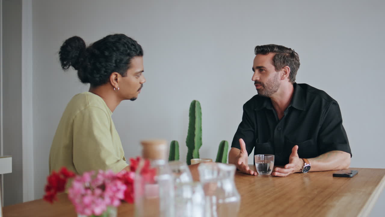 dos hombres multiétnicos descansando en una cafetería de cerca. una pareja hablando en la cafetería