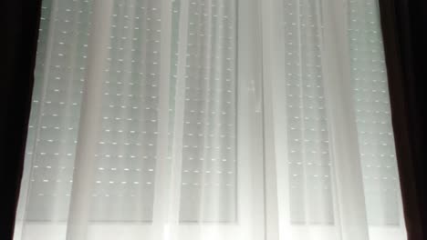 automatic window blind cover window with white curtains during the day light