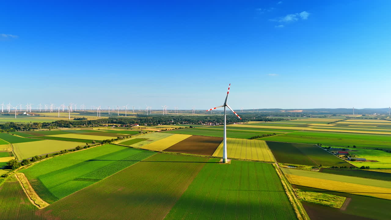 Working wind turbine producing clean energy. Wind farm in the countryside at backdrop. Aerial view.