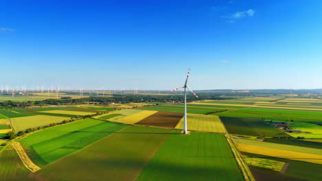 working wind turbine producing clean energy. wind farm in the countryside at backdrop. aerial view.