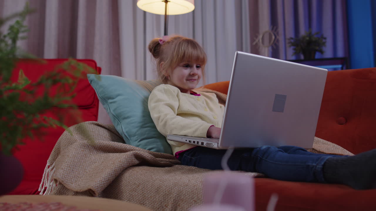 niña pequeña de escuela que usa una computadora portátil aprende a leer lecciones de educación en línea sola en casa