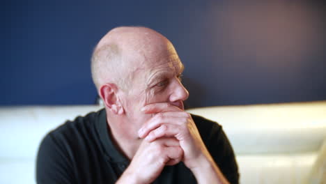 a mature senior man with mental health problems is sitting at home pensive looking lost and confused