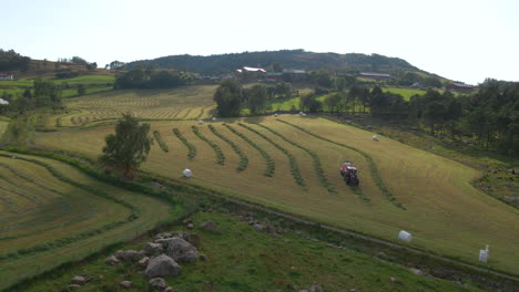 Tractor-Agrícola-Con-Empacadora-Recoge-Hileras-Para-La-Producción-De-Ensilaje-En-Hjelmeland,-Rogaland,-Noruega