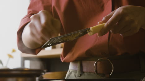 Woman grating cheese in the kitchen