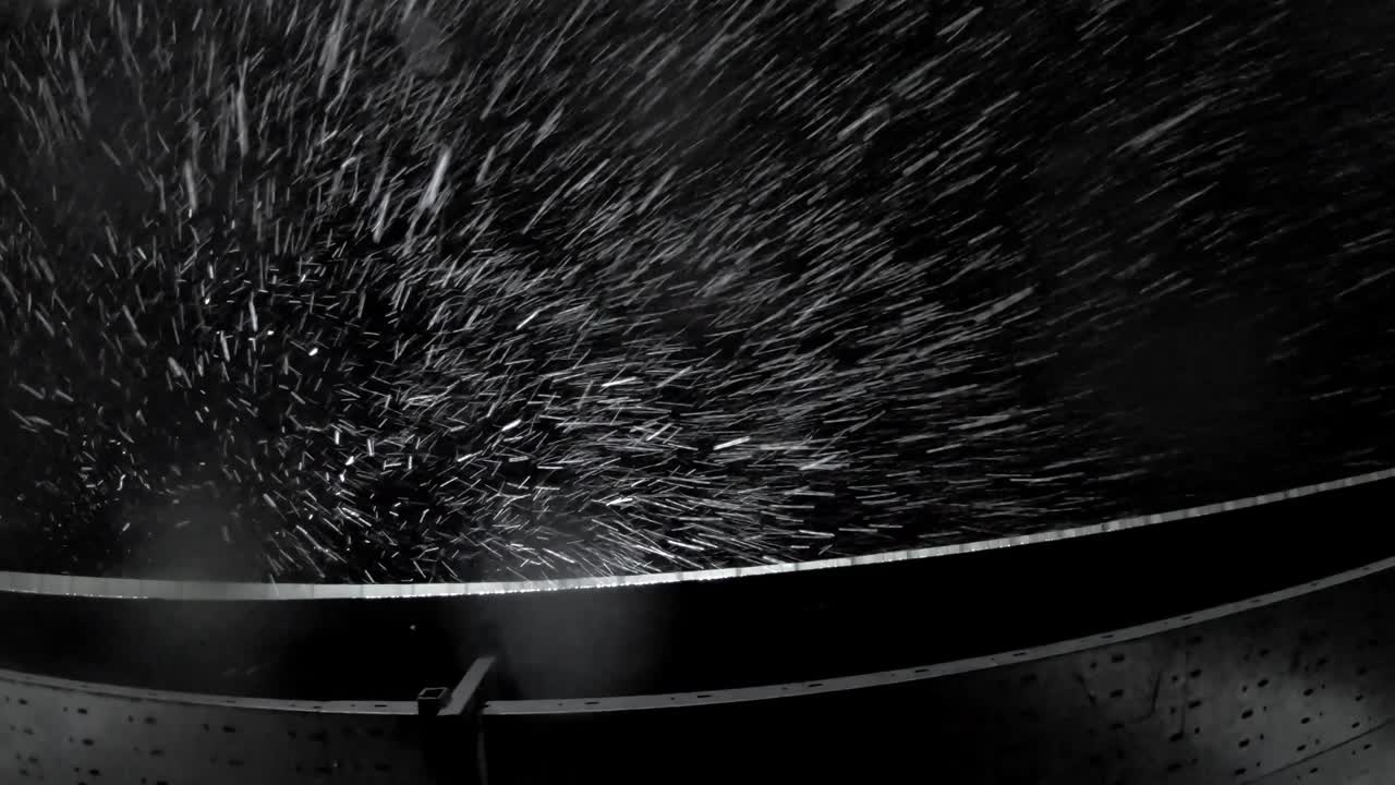 падающие капли дождя или снег ночью под светодиодным освещением и крышей здания