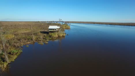 an aerial over the louisiana bayou reveals a house on stilts 1