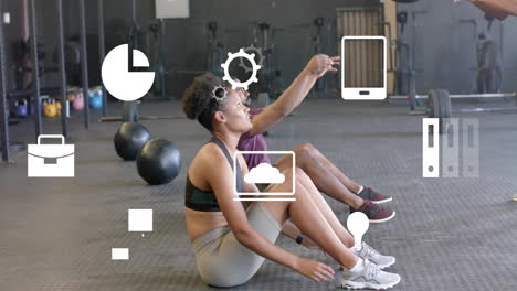 animation of business icons over diverse sports people exercising with balls at gym