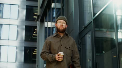 man with coffee cup walking in a modern city