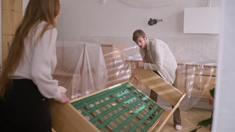 una pareja montando una cama durante una renovación de la casa