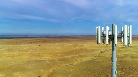 4k hizo imágenes volando de cerca por una torre celular rodeada de colinas doradas y cielos azules