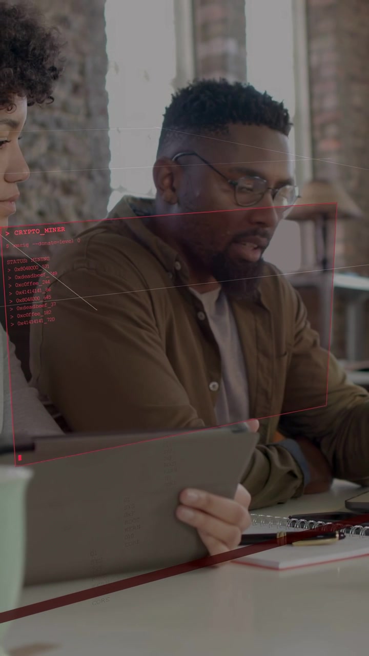 Vertical video: Man reading tablet as peer holding it in loft causing red HUD, giving design notes
