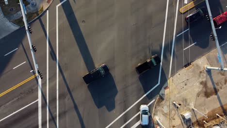 An-overhead-aerial-view-of-a-busy-4-way-intersection,-located-in-a-small-town,-at-30-frames