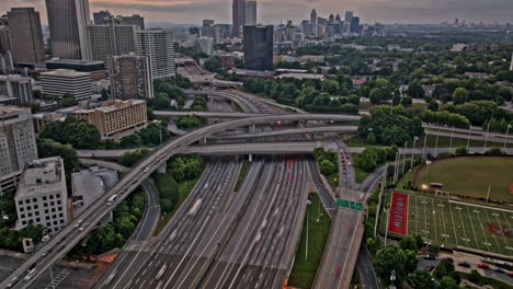 Vista-Aérea-De-Pájaro-Con-Hiperlapso-V878-De-Atlanta-Georgia,-Paso-Elevado-Inverso-De-Color-Castaño-Rojizo-Capturando-El-Tráfico-De-Las-Autopistas-Interestatales,-La-Inclinación-Hacia-Arriba-Revela-El-Paisaje-Urbano-Del-Centro-De-La-Ciudad---Filmado-Con-Mavic-3-Pro-Cine---Mayo-De-2023