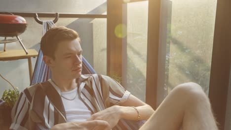 young man relaxing in hammock indoors - close up