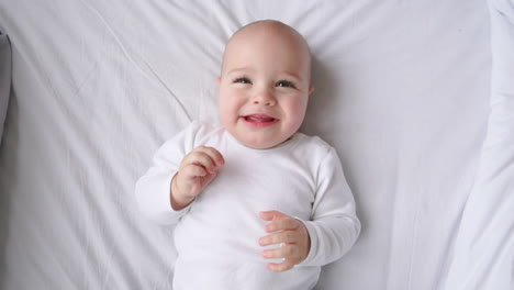 cute little baby lying on bed, top view