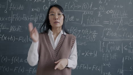 teacher explaining mathematics on a blackboard