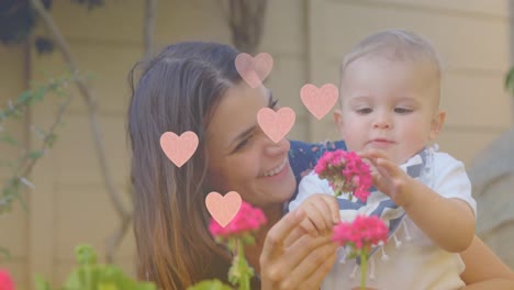la animación de los corazones sobre la feliz madre caucásica sosteniendo al bebé