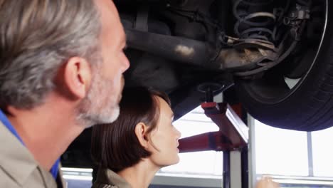 mecánicos que interactúan entre sí mientras reparan un coche