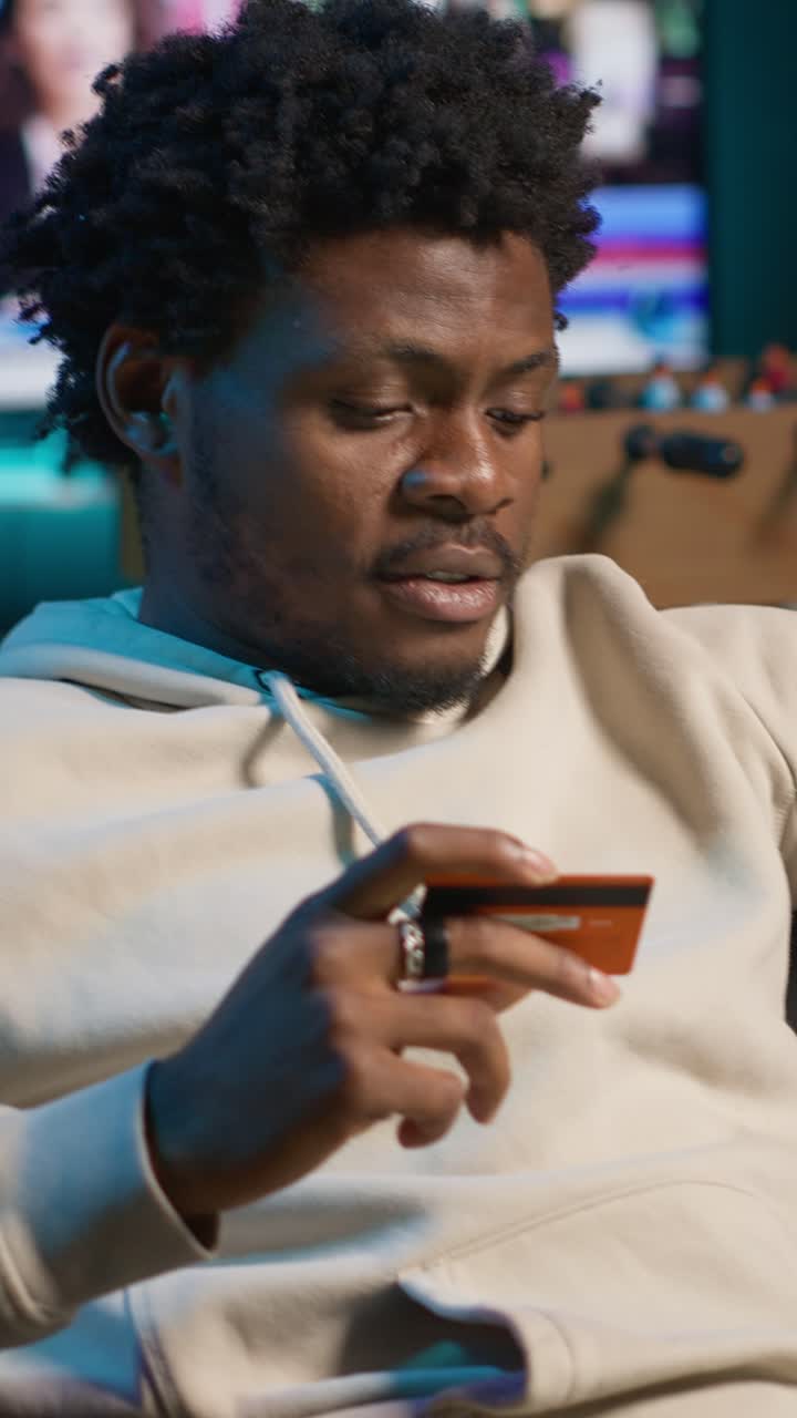 Young African American Man Holding Credit Card for Online Shopping