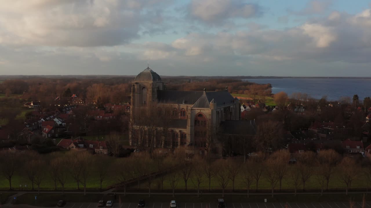 Revealing shot of the big Church of Veere from the canal. Drone orbital shot towards the church