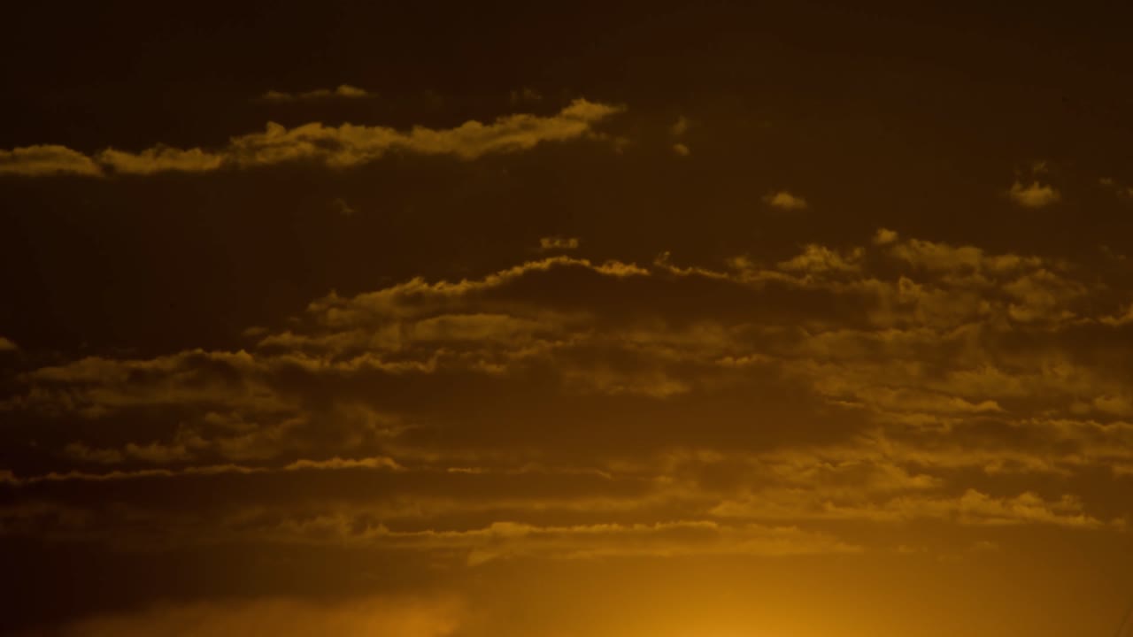 Timelapse at cloudy sunset with zoom of sun