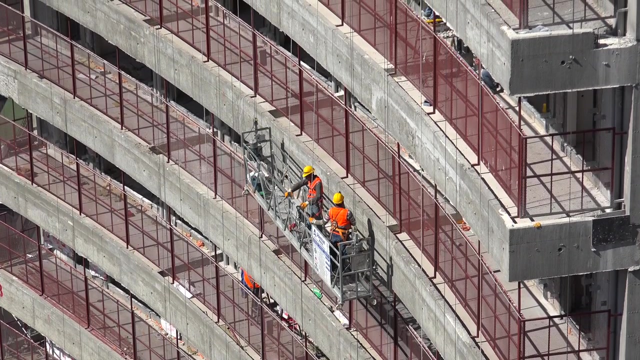 Construction Workers on Suspended Platform Working on High-Rise Building