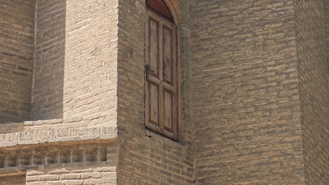 Antico muro di mattoni con portone in legno ad arco