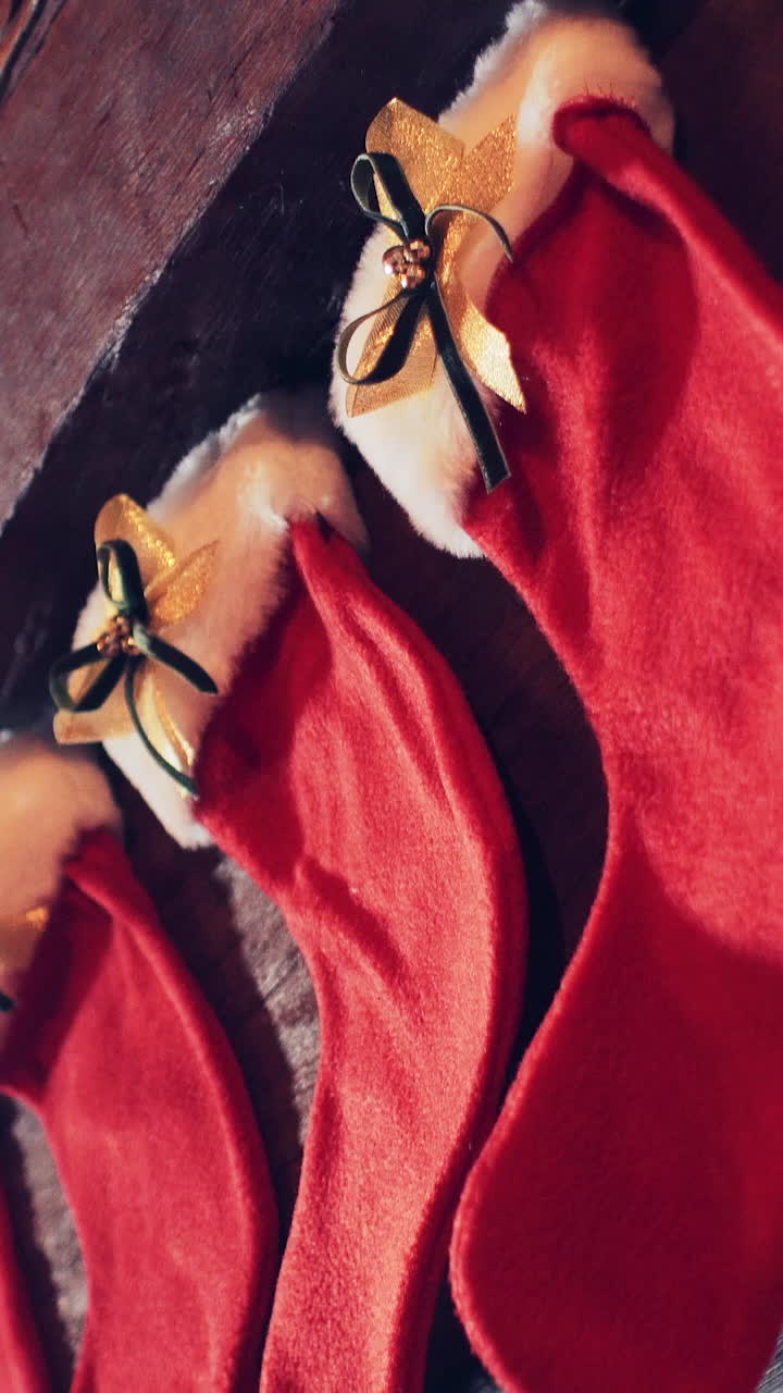 Red Christmas stockings for gifts on the fireplace near the Christmas decorations. Vertical video