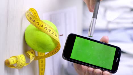 video vertical del nutricionista apunta al teléfono inteligente con pantalla verde, alimentación saludable