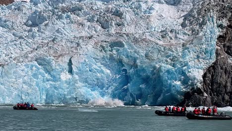 tourists in zodiac boats see the sawyer glacier calving in alaska