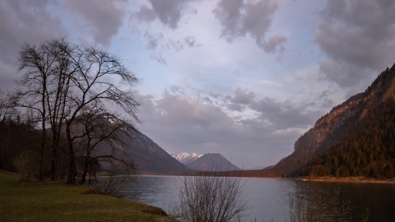 nubes de amanecer moviéndose sobre un lago, lago sylvainstein alpes bávaros baviera alemania