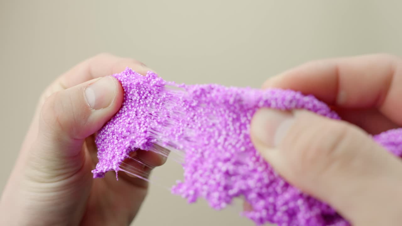 Hands squeezing bright pink floam, soft texture play, calming and satisfying moment