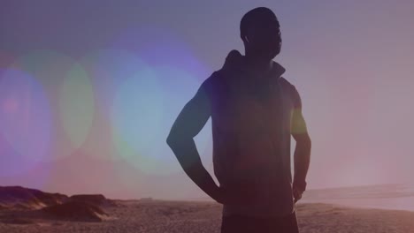 animación de puntos sobre hombre afroamericano estirándose en la playa