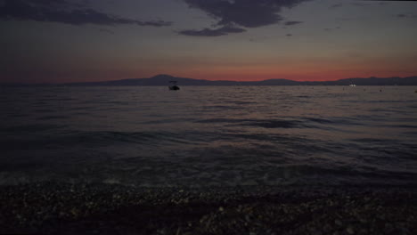 statische aufnahme eines wunderschönen sonnenuntergangs am meer von kalamata, sommer 2020, beruhigende wellen im vordergrund 4k