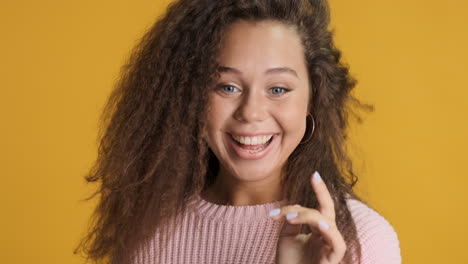 caucasian curly haired woman smiling to the camera.